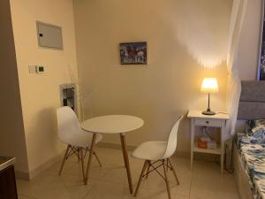 um quarto com uma mesa e duas cadeiras e uma cama em Studio Appartment in Building em Ras al-Khaimah