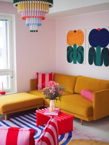 a living room with two yellow couches and a table at Candy-Colored Two-Room Condo with Sweet views in Helsinki