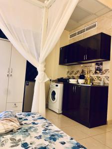 a kitchen with a washer and dryer in a room at Studio Appartment in Building in Ras al Khaimah