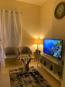 uma sala de estar com uma televisão de ecrã plano sobre uma mesa em Studio Appartment in Building em Ras al-Khaimah