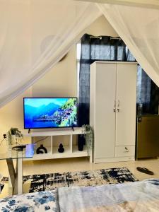 a living room with a television on a white cabinet at Studio Appartment in Building in Ras al Khaimah