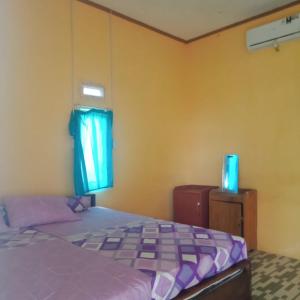 1 dormitorio con cama y ventana en Karang Besi Losmen en Biha