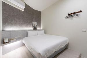 ein Schlafzimmer mit einem großen weißen Bett in einem Zimmer in der Unterkunft 礁溪亞都溫泉旅店 Newly Renovated in Jiaoxi