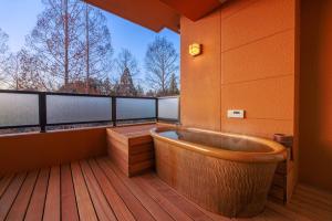 a balcony with a tub on a wooden deck at Saiou no Miya in Ise