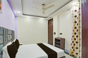 una camera con letto e ventilatore a soffitto di OYO Flagship Starx Inn a Nuova Delhi