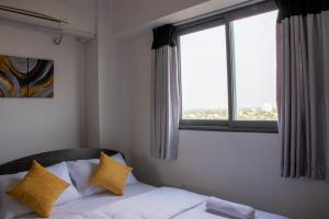 um quarto com uma cama com almofadas amarelas e uma janela em Lovish luxury villa em Colombo
