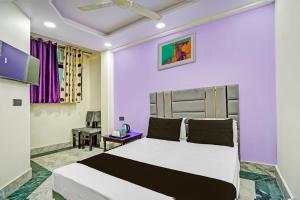una camera con letto e parete viola di OYO Flagship Starx Inn a Nuova Delhi