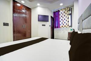 una camera con un grande letto e una TV di OYO Flagship Starx Inn a Nuova Delhi