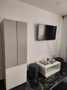 - un salon avec une télévision sur un mur blanc dans l'établissement Súkromný luxusný apartmán, à Hlohovec