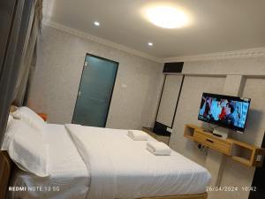 una camera d'albergo con un letto e una televisione di Arasan Residency a Kotagiri