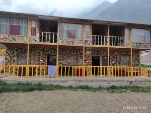 a building with a yellow fence in front of it at Hotel Inn Badrinath Stay in Badrīnāth