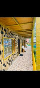 a yellow building with a walkway with benches on it at Hotel Inn Badrinath Stay in Badrīnāth