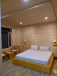 ein Schlafzimmer mit einem Bett in einem Holzzimmer in der Unterkunft Hotel Inn Badrinath Stay in Badrīnāth