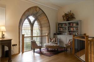 an archway in a room with a chair and a table at Greystead Old Church in Hexham