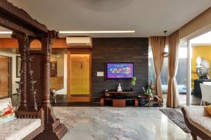 a living room with a tv on a wall at JalMahal by JadeCaps Bay View & Pool Dabolim in Vasco Da Gama
