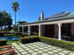 una casa con piscina frente a ella en La Terrazza, en Riebeek-Wes