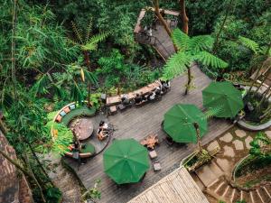 een uitzicht op een houten terras met groene parasols bij Country side room northern UBUD in Tegalalang