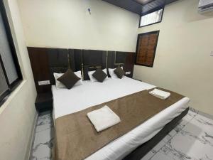a bedroom with a large bed with white sheets and pillows at Hotel Star light by Shri Shyam in Ujjain