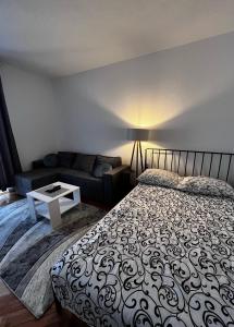 a bedroom with a bed and a couch at Apartman RISTIC in Vranje