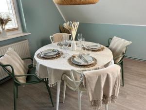 a dining room table with a white tablecloth and chairs at Appartement No 1 - Usedom in Zirchow