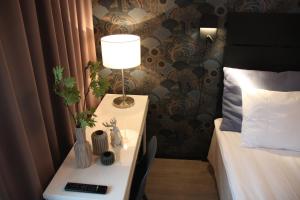 a table with a lamp on it next to a bed at Hotel Aakenus in Rovaniemi