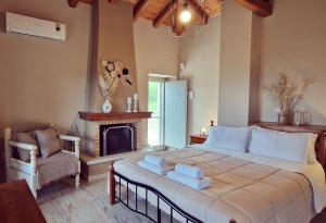 a bedroom with a large bed and a fireplace at Arxontiko Taygeti in Mystras