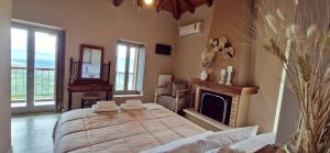a bedroom with a large bed and a fireplace at Arxontiko Taygeti in Mystras