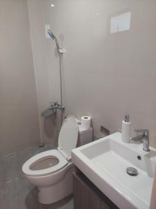 a white bathroom with a toilet and a sink at MaClare Resort in Imus