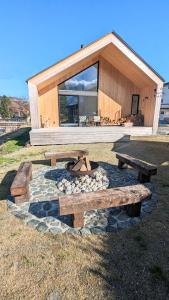 a house with a fire pit and benches in front of it at JOKIJOKI Hakuba in Hakuba