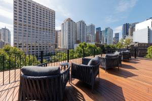 a row of chairs on a deck with a city skyline at 202 Elizabeth Hotel - The Oxford - Australia in Sydney