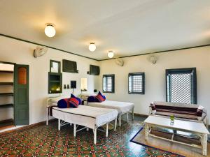 ein Wohnzimmer mit 2 Betten und einem Sofa in der Unterkunft Mangaldas Ni Haveli I by The House of MG in Ahmedabad
