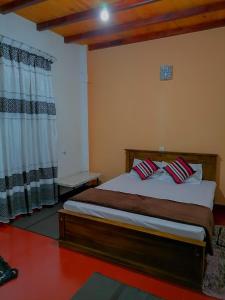 Un dormitorio con una cama con almohadas. en Tea Bound Resort, en Nuwara Eliya