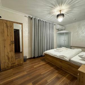 Un dormitorio con una cama grande y una lámpara de araña. en Cozy Hostel, en Yunusobod