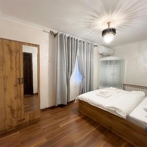 1 dormitorio con cama y lámpara de araña en Cozy Hostel, en Yunusobod