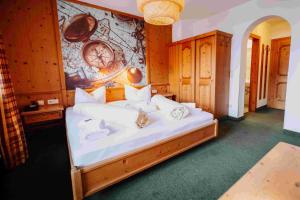 1 dormitorio con 1 cama con sábanas y almohadas blancas en Scharler's Hotel, en Uttendorf