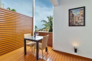 a balcony with a glass table and two chairs at StayVista at Acacia Skies with Beach View & Kitchen Access in Vasco Da Gama