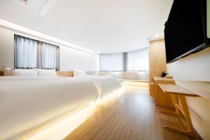 Brown-Dot Hotel Damyang في داميانغ: غرفة نوم بسريرين وتلفزيون بشاشة مسطحة