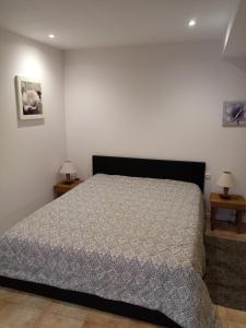 - une chambre avec un lit et deux tables de chevet dans l'établissement Gîte de la Noyelle à Sainghin en Mélantois, à Sainghin-en-Mélantois