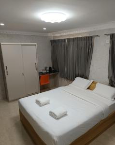 una camera da letto con un letto grande con due asciugamani sopra di Arasan Residency a Kotagiri
