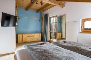 a bedroom with two beds and a flat screen tv at Bayerwaldchalet in Regen