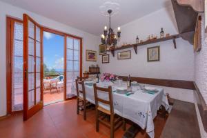 a dining room with a white table and chairs at Villino Di Corsanico With View - Happy Rentals in Massarosa