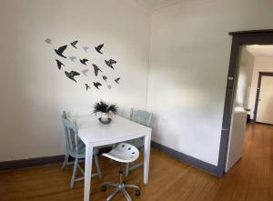 a room with a table with chairs and birds on the wall at Budget 1 bedroom unit near Maroubra Beach in Sydney