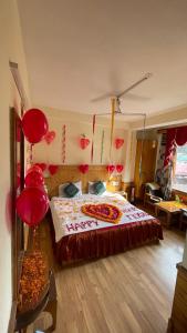 a bedroom with a bed with red decorations on the wall at Hotel Snow Mountain Mall Road in Manāli