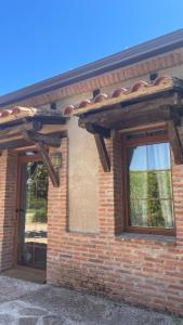 un edificio in mattoni con due finestre e un tetto di Apartamento Cebada a Valladolid