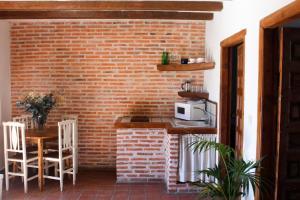 una cucina con muro di mattoni e tavolo con forno a microonde di Apartamento Cebada a Valladolid