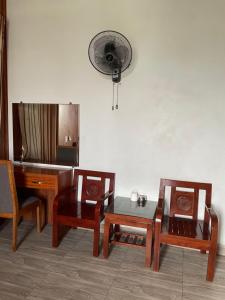 海陽的住宿－Trúc Lâm hotel，客房设有椅子、桌子和风扇。