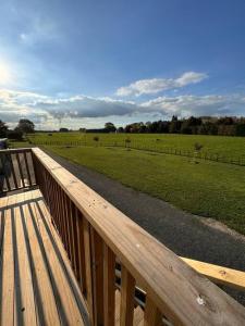 a wooden deck with a view of a field at Countryside peace and comfort , in Cambridge