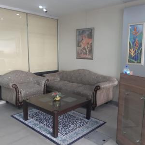uma sala de estar com um sofá e uma mesa de centro em Premier Inn Davis Road Lahore em Lahore
