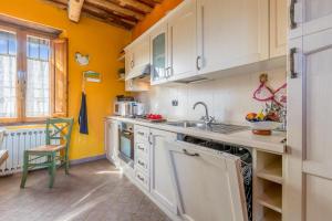 eine Küche mit weißen Schränken und einem Waschbecken in der Unterkunft Casale Geniva with Private Pool - Happy Rentals in Massarosa