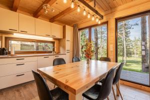 eine Küche und ein Esszimmer mit einem Holztisch und Stühlen in der Unterkunft Forest Princess Chalet - Happy Rentals in Nova Vas